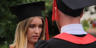 漂亮的女人在毕业典礼后与毕业男友谈话