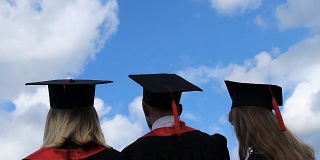 毕业生们的美好未来，三个学生将学术帽抛向空中