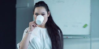 一个亚洲女人在会议室喝茶