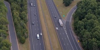 空中镜头:早上在州际公路上飞驰的半卡车和私家车