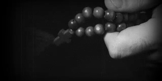 用念珠十字架祈祷的手。