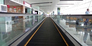 自动扶梯正在移动，可以看到商店和机场的人。