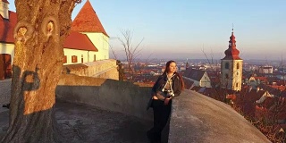 4 k。美丽的女孩看全景从城堡在斯洛文尼亚的老城普图伊。日落时间-编辑
