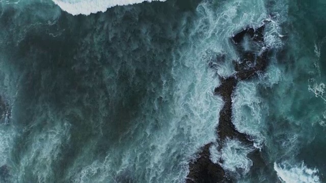 空中的慢动作镜头海浪冲向岩石海岸