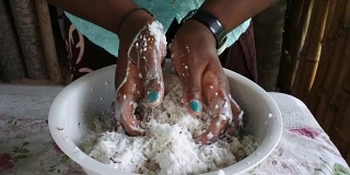 斐济土著妇女的手挤压椰子水果奶油在斐济