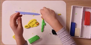 儿童工艺品从粘土塑造在板上雕刻，加速，特写，顶视图