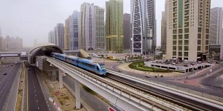 火车在阿联酋迪拜摩天大楼之间的高速公路上越过高架桥