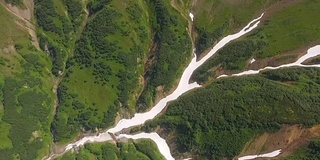 从底部向上看火山。冰冻的河流，附近有雪和草