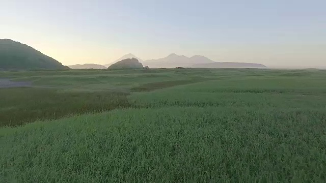 鸟瞰图。低低地飞过田野。美丽的山景。