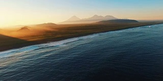 海上最美丽的日落。在远处的山上有雾。空中拍摄