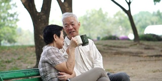 随意的老快乐的亚洲高级在公园一起喝咖啡