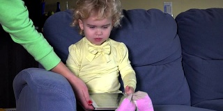 小孩子哭的时候妈妈就用手拿走平板电脑。电脑成瘾