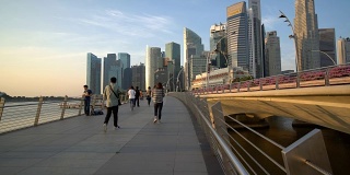 人们走在新加坡滨海湾，以摩天大楼为背景