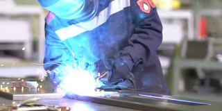 人工焊工以慢动作焊接结构部件。
