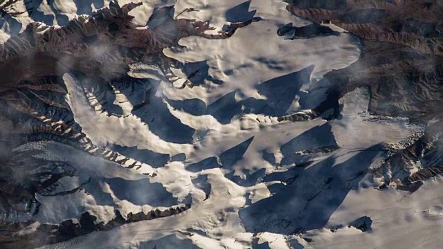 在国际空间站上飞越地球。飞过雪山，从太空鸟瞰。