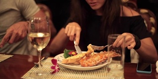 女人用叉子和刀在盘子上吃龙虾的特写手
