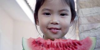 特写亚洲小女孩吃西瓜，慢镜头