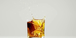 两块冰块掉进波旁威士忌酒杯里。慢动作