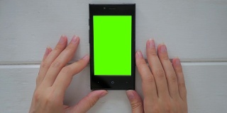 一个女人在看绿色屏幕的智能手机