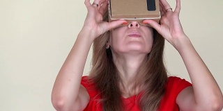严肃的女人用纸板虚拟眼镜