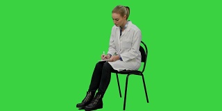 女医生在绿屏上为病人写处方，色度钥匙