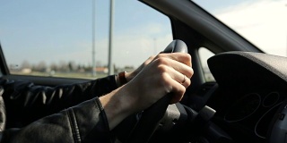 男人在城市里开车-方向盘和手的细节