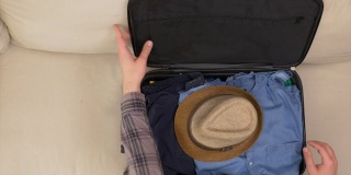 一名男子将衣服装进旅行袋