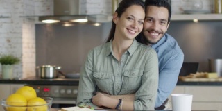 厨房里一对微笑的英俊夫妇的肖像。