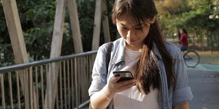年轻女孩使用智能手机走路