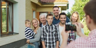 一个男人在室外为他的大家庭拍照。