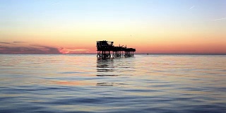 日落时海上石油平台的剪影