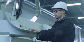 安全帽工程师在工厂安装数控机床