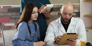 医疗保健:一组医生在诊所或医院用平板电脑讨论和检查x光。FHD FullHD