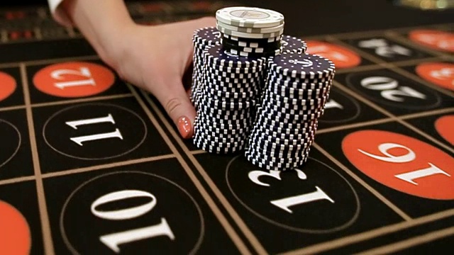 Croupier moves chips on table at casino