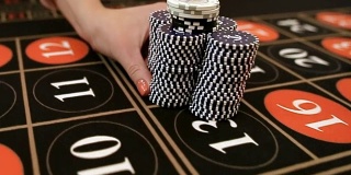 Croupier moves chips on table at casino