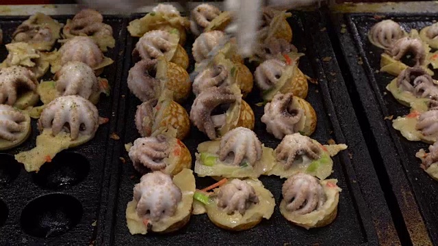 烹饪球形街头小吃饺子与大鱿鱼油炸小吃在日本。