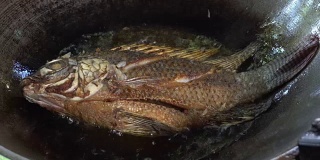 近距离煎罗非鱼在平底锅与沸腾的油。
