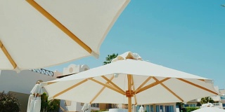 豪华酒店的绝佳休息。一排雪白的雨伞映衬着蓝天的背景。替身拍摄