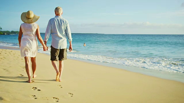 日落时分，在海滩上散步的幸福夫妇