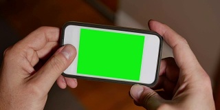 一男子用绿屏智能手机玩游戏