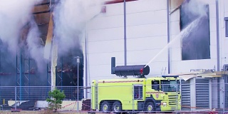 消防车正在努力控制工业大楼的大火
