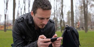 一个男人在公园里玩手机