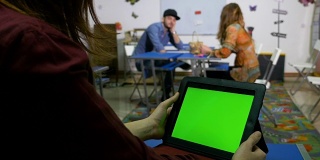 青少年在课堂上用绿屏平板电脑社交