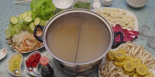 亚洲美食的概念。经验丰富的厨师把肉汤倒进特制锅的第二间办公室