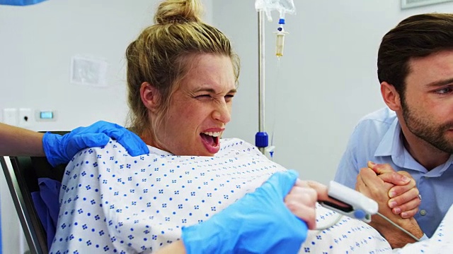 一名男子在手术室牵着孕妇的手