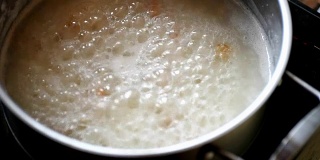 在不锈钢锅中加入开水，用木勺将米饭混合