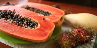 餐桌上有异国情调的热带水果。泰国的水果。番木瓜，切成两半。特写镜头