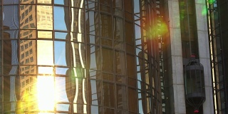 现代商业办公大楼的玻璃电梯在阳光下移动