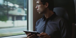 一名男子在火车上使用平板电脑