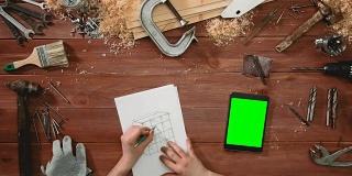 俯视图工匠手绘柜体效果图，数字平板绿屏躺在桌面上